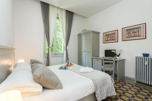 布雷西亚The Leoncino Hotel的卧室配有一张白色大床和一张书桌