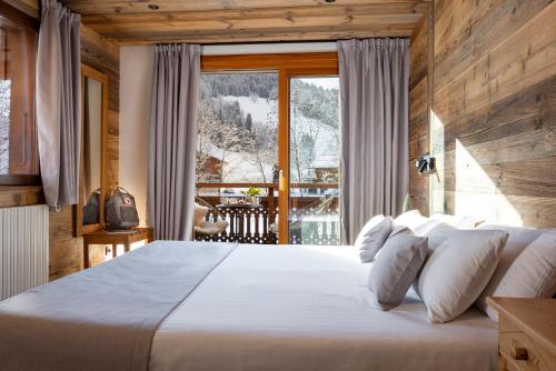 大博尔南Hôtel et Spa Le Vermont的一间卧室设有一张大床和一个大窗户