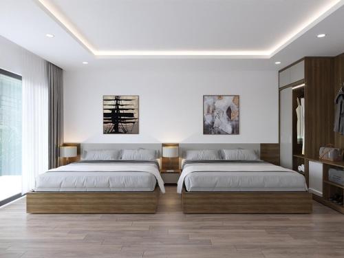 宁平Tam Coc LiLy Homestay的卧室设有两张床,拥有白色的墙壁和木地板