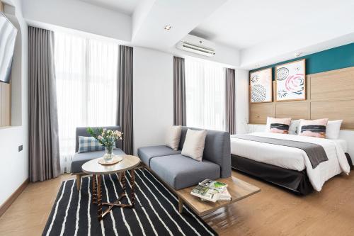 清迈Darley Hotel Chiangmai的酒店客房,配有床和沙发