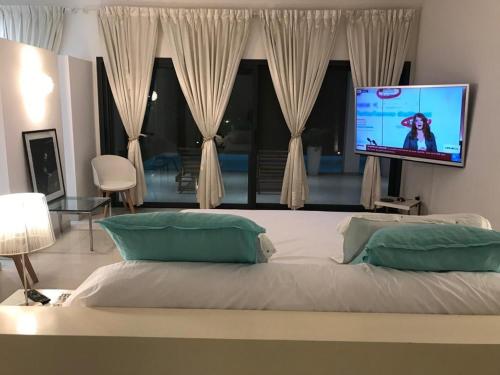 索蒙Villa Carabane的一间卧室设有一张大床和一台平面电视。