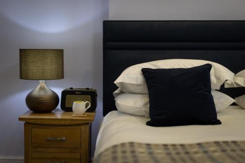 卡迪根卡莫尔甘宾馆的一张带黑色床头板的床和一张带时钟的桌子