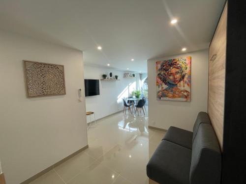 拉格朗德默特Grand studio en centre ville et à 50 mètres du port, climatisé的客厅配有沙发和墙上的绘画