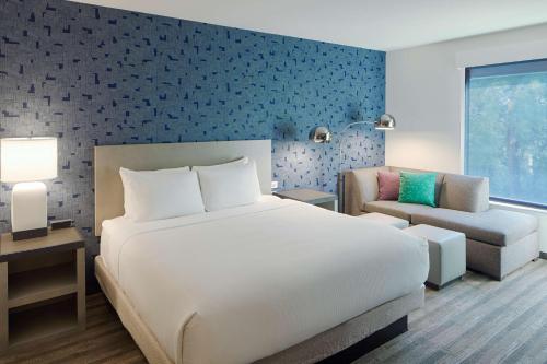 哥伦布Hyatt House Columbus OSU Short North的卧室配有一张白色的大床和一张沙发。