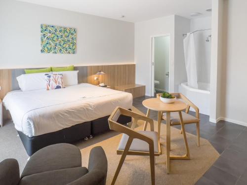 仙女港A1 Motels and Apartments Port Fairy的卧室配有1张床、1张桌子和1把椅子