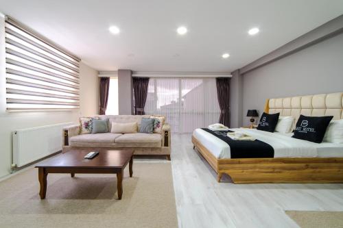 伊斯坦布尔Best Hotel Pendik的一间卧室配有一张床、一张沙发和一张桌子