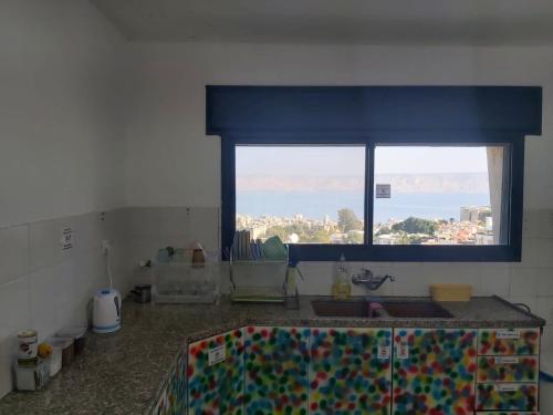 提比里亚turtle guesthouse- tiberias的厨房设有窗户和带水槽的台面