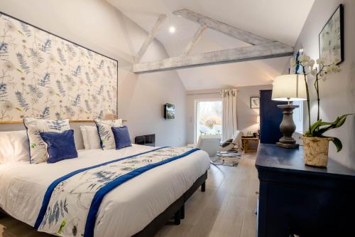 GergyDomaine De L´Oiseau的一间卧室配有一张带蓝白色枕头的大床