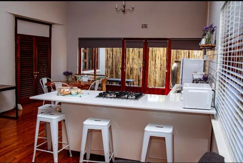 博福特西The Grey House的厨房配有带凳子和水槽的台面