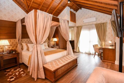 格拉玛多穆勒大叔小屋酒店的一间卧室,卧室内配有一张天蓬床