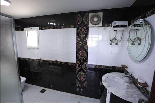 杜拉特阿拉尔فيلا درة العروس的黑白浴室设有水槽和卫生间