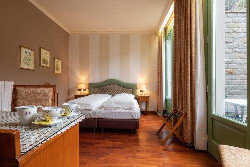 塞斯托拉Hotel Roma的一间卧室配有床和一张桌子,上面有盘子