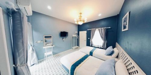 Ban Na Oiลิลล์ลดา บูติค โฮเต็ล的一间拥有蓝色墙壁的卧室,其中配有一张床