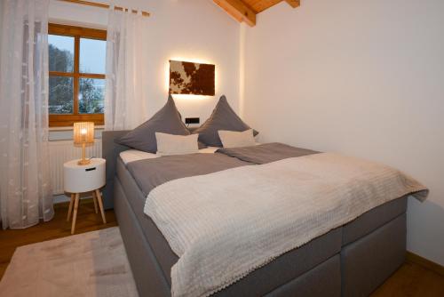 博登迈斯Bodenmaiser Herz-Hoamad Ferienwohnung Bierl的卧室在窗户前配有一张大床
