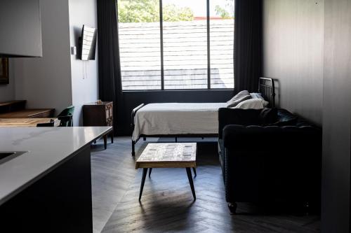 泰勒博恩Le Black & White - Vieux-Terrebonne的客厅配有床、沙发和桌子