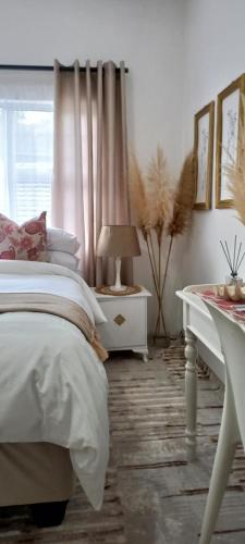德班Orange Leaf Guesthouse Durban North的一间卧室配有一张床和一张带台灯的桌子