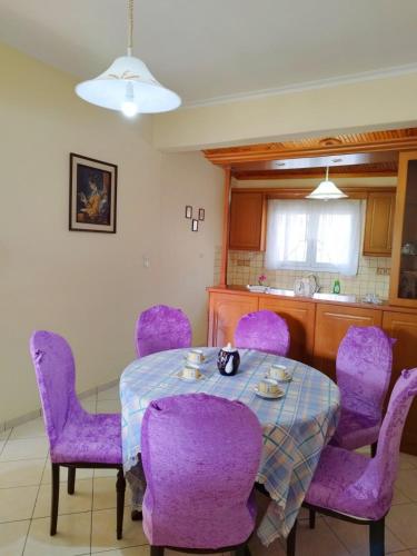 约阿尼纳Zoi Country Home by Eutopia的一间用餐室,配有紫色椅子和一张桌子