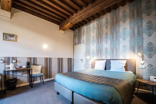 布鲁日Hotel karel de stoute的配有一张床和一张书桌的酒店客房
