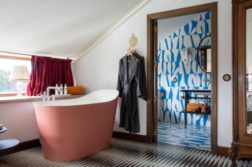 圣地亚哥－德孔波斯特拉Casa Beatnik Hotel的一间带浴缸的浴室,毗邻窗户