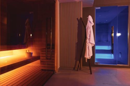 拉韦洛Moma Hotel Wellness & Spa的浴室的杆子上挂着一件长袍