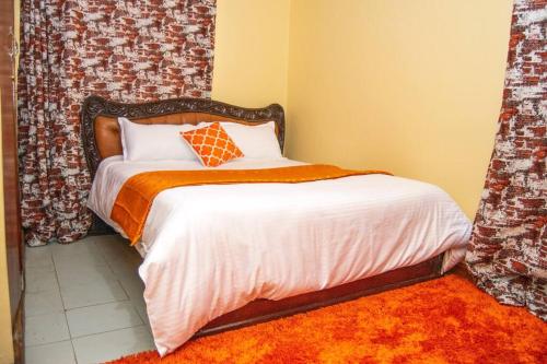 尼耶利Jenna stays的一间卧室配有带橙色和白色枕头的床
