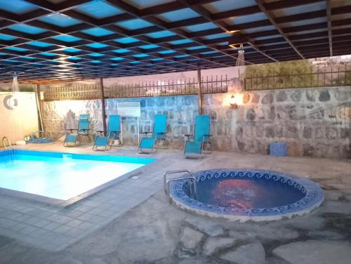 阿尔哈姆拉The Wadi Inn的一个带椅子的游泳池和一个热水浴缸
