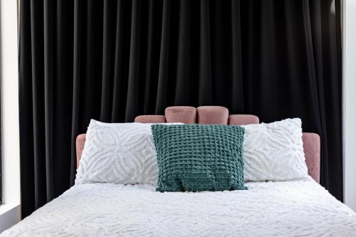 泰勒博恩Le Virtuose - Vieux-Terrebonne的一张带绿色和白色枕头的床