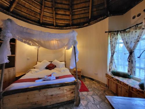 内罗毕Edaala Comfort - Cottage Rooms的一间卧室配有一张带天蓬的床