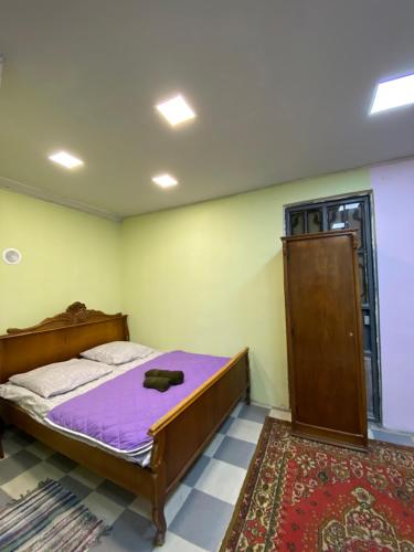 埃里温Vahe’s family guests house的一间卧室配有一张带紫色床垫的床