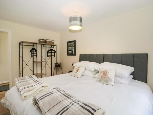 马姆斯伯里Orchard House Cottage的一间卧室配有带白色床单和枕头的床。