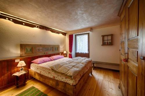努斯Le Bibelot apartments的卧室配有一张带粉红色枕头的大床