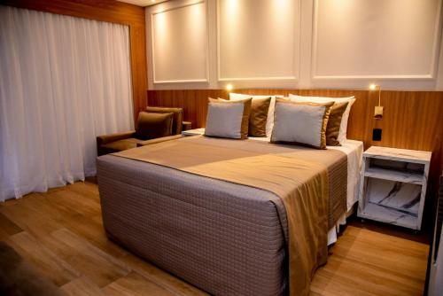 佩尼多Hotel Titanic Penedo的一间卧室配有一张大床和一把椅子