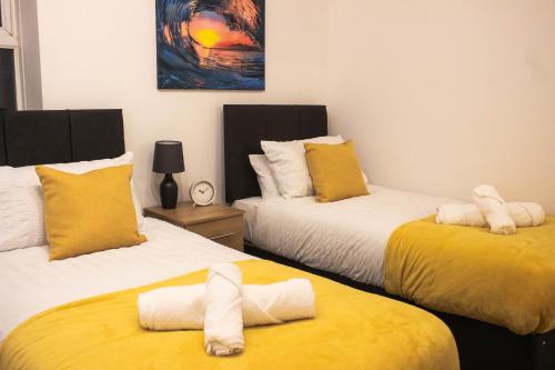 斯旺西Business friendly 3BR home - King size beds & Centrally located的一间卧室配有两张带毛巾的床
