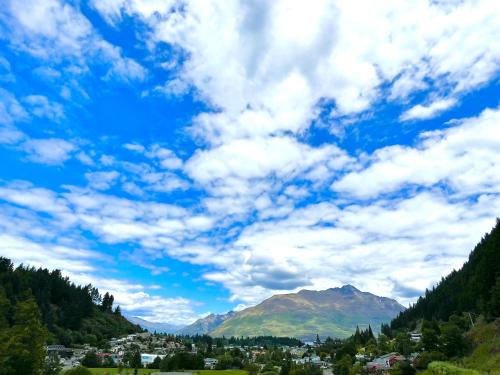 皇后镇Queenstown Retreat的一座城镇和高山上空的云天