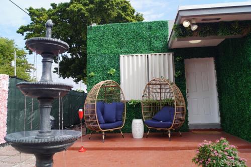 迈阿密Art Gardens Wynwood concept的喷泉旁的两把椅子和一个鸟笼