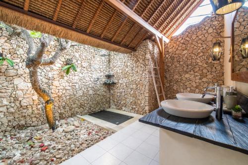 蓝梦岛兰博甘爱别墅的一间带两个水槽和石墙的浴室