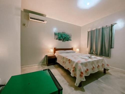 弗洛里亚诺波利斯Garden 437 Estúdios的一间卧室配有一张床和一张绿桌