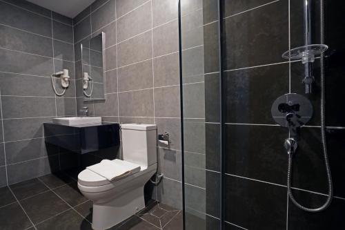 怡保Sunway Onsen Hospitality Suites的一间带卫生间和玻璃淋浴间的浴室