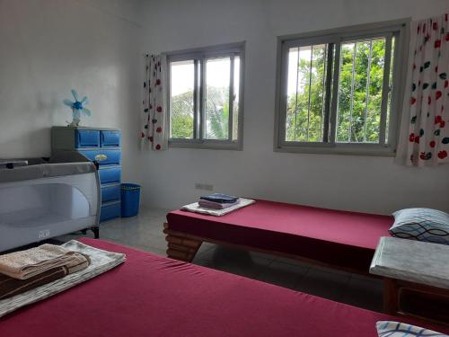 AgnaySPANISH VILLA Lonos ROMBLON的客房设有床、水槽和2扇窗户。