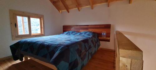 皮纳尔-德阿莫莱斯Colibri - Cabañas Puerto del Zopilote的一间卧室配有一张带蓝色棉被的床和窗户。
