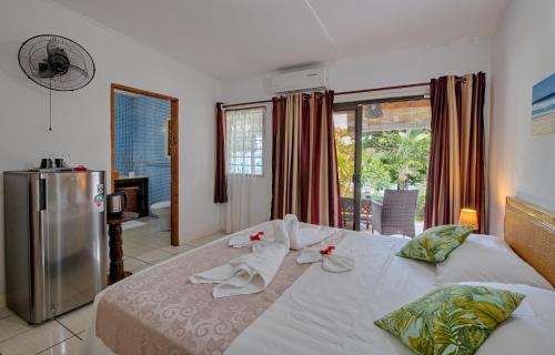博瓦隆The Beach House的卧室配有一张白色大床,床上有红色的鲜花