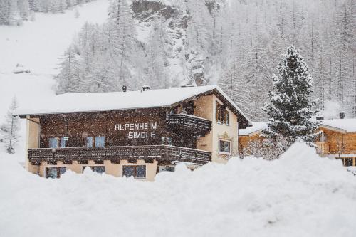 索尔登阿尔盆黑姆西蒙娜酒店的树旁的雪覆盖的建筑