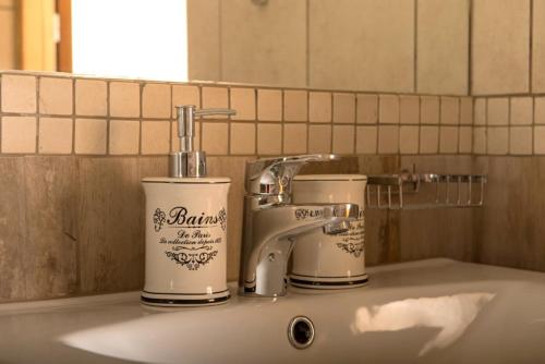 艾斯特根eHotel Esztergom的浴室水槽,配有2个杯子和水龙头
