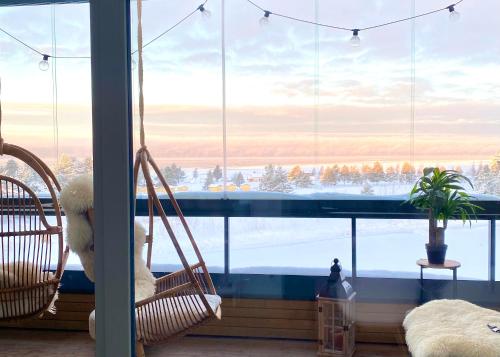 卡拉约基SunBeach Apartment with seaview and sauna的一间设有两把摇椅的客房,位于大窗户前
