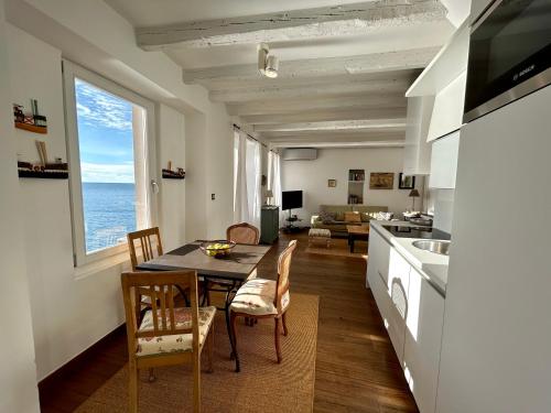 罗维尼Apartment Mediterraneo的厨房以及带桌椅的起居室。