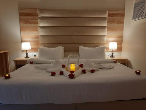 乌姆莱季فندق دريم أملج的一张带蜡烛和玫瑰的床
