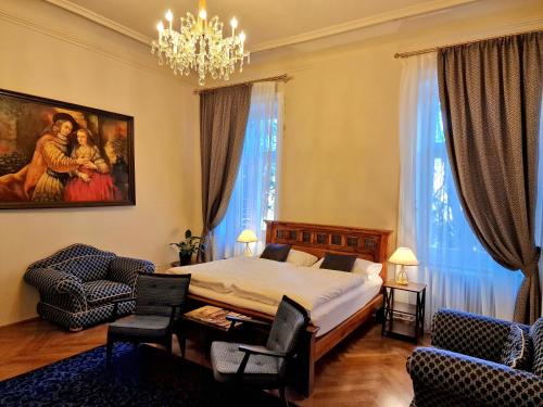 BurgauPalais Kneissl的一间卧室配有一张床、两把椅子和一个吊灯