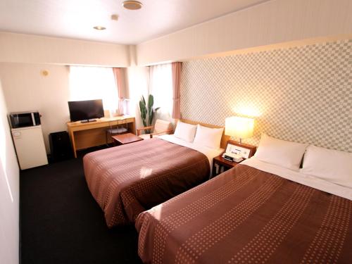 千岁HOTEL LiVEMAX BUDGET Chitose的酒店客房设有两张床和电视。