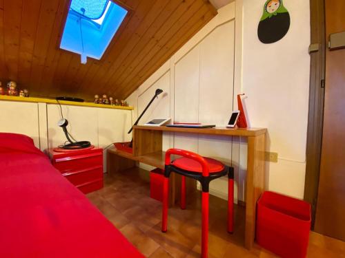 伊莫拉Matrioska House B&B的一间卧室配有书桌和红色凳子