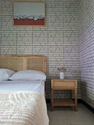 TjolomaduEl jenna syariah villas的一间卧室配有一张床和一张边桌